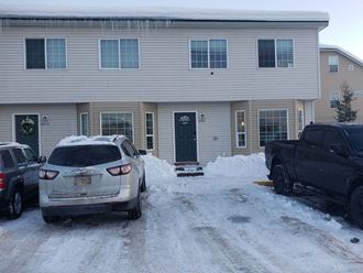 a house with cars parked in front of it in the snow