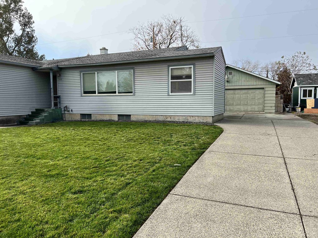 a blue house with a lawn and a sidewalk