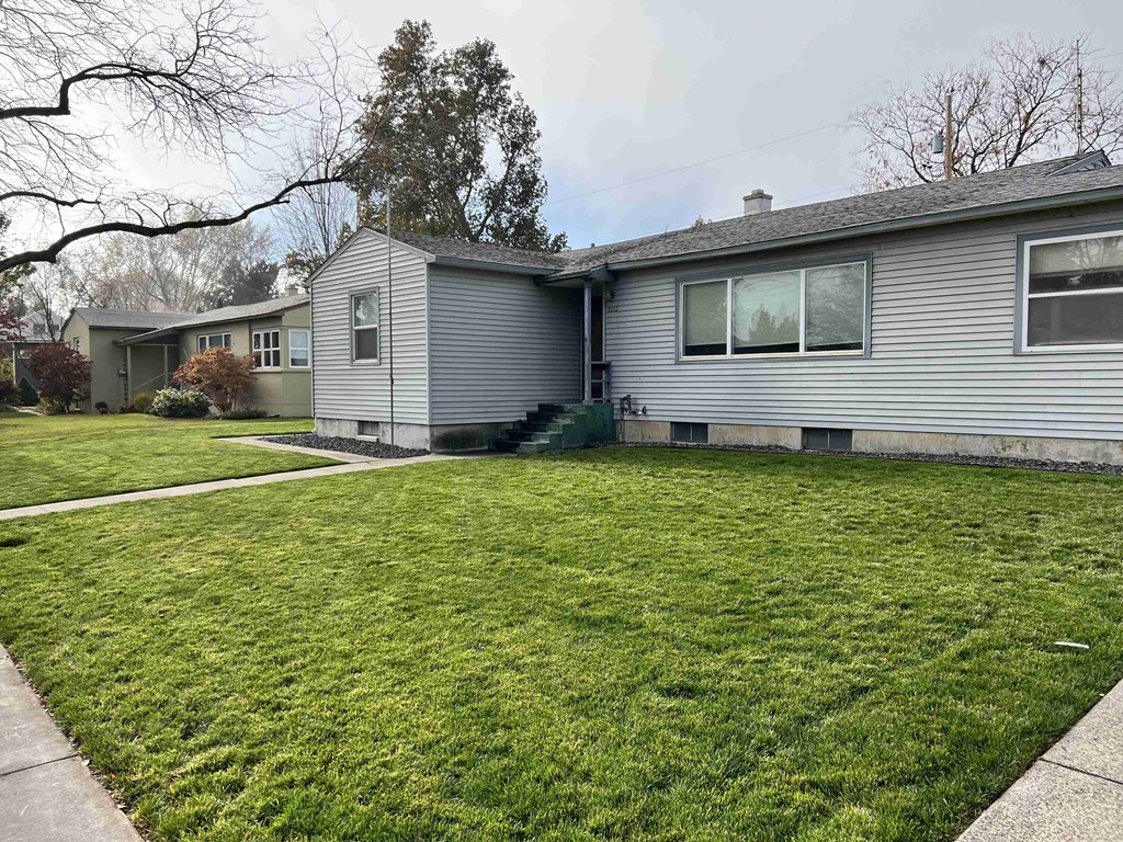 a white house with a green lawn in front of it