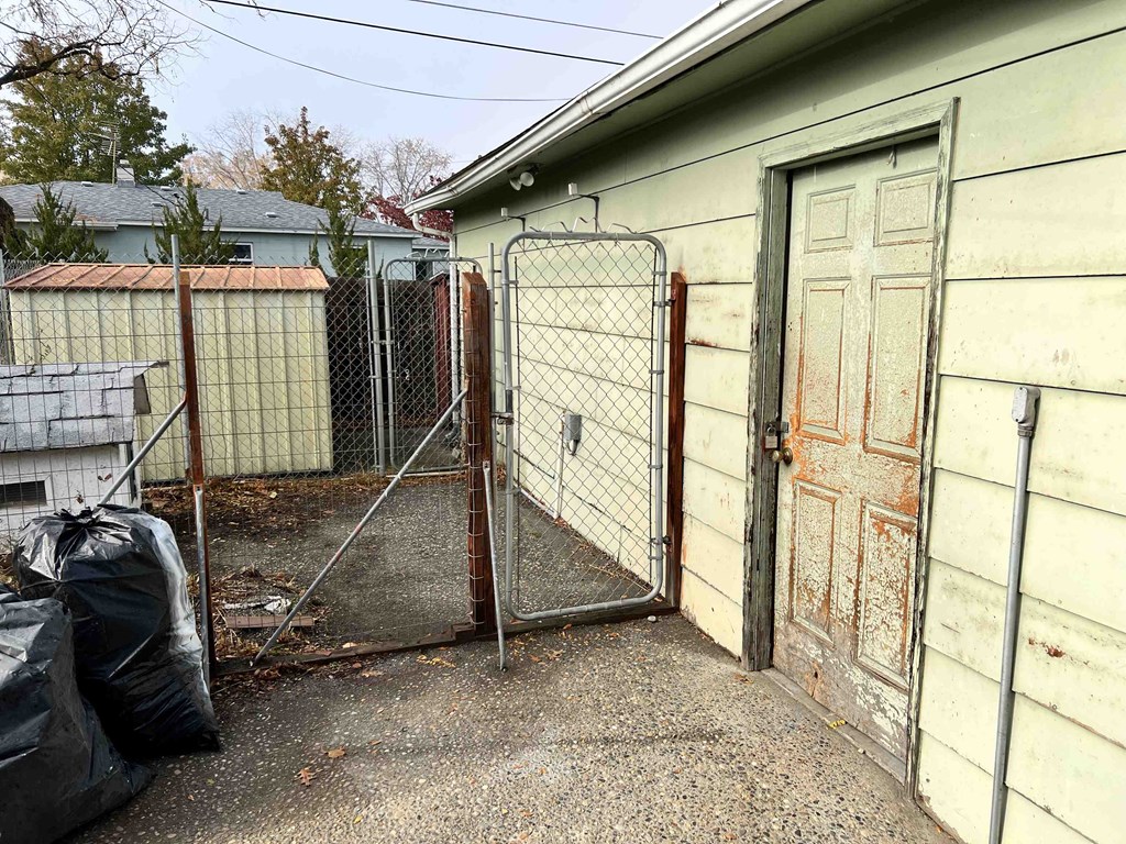 the back of a house with a fence and a gate