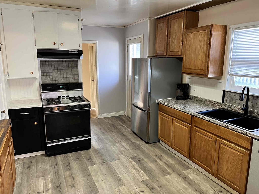 a kitchen with black appliances and wooden cabinets