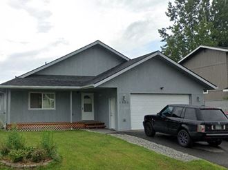 a black car parked in front of a house