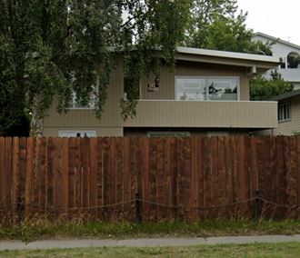 a house with a wooden fence in front of it
