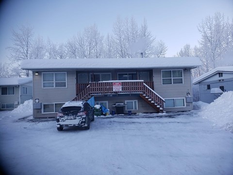 A house with a car parked in front of it.