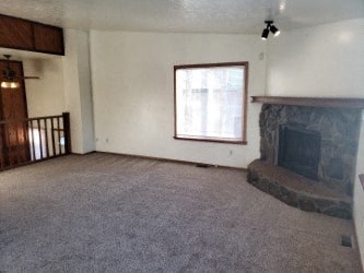 A living room with a fireplace and a window.