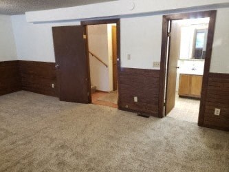 A room with carpeted floor and three doors.
