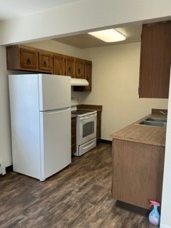 A kitchen with a white refrigerator and wooden cabinets.