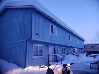 a blue house with snow in front of it