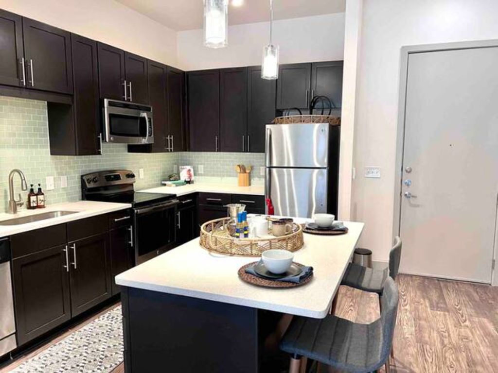 a kitchen with black cabinets and a white counter top