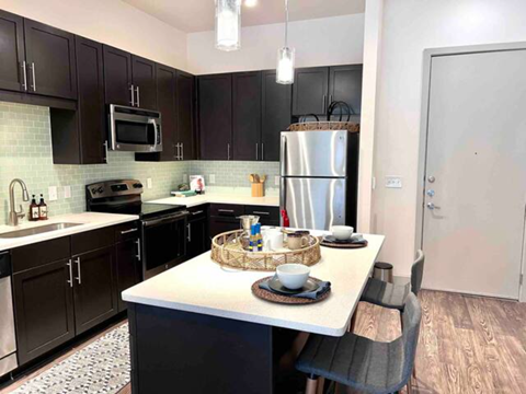 a kitchen with black cabinets and a white counter top