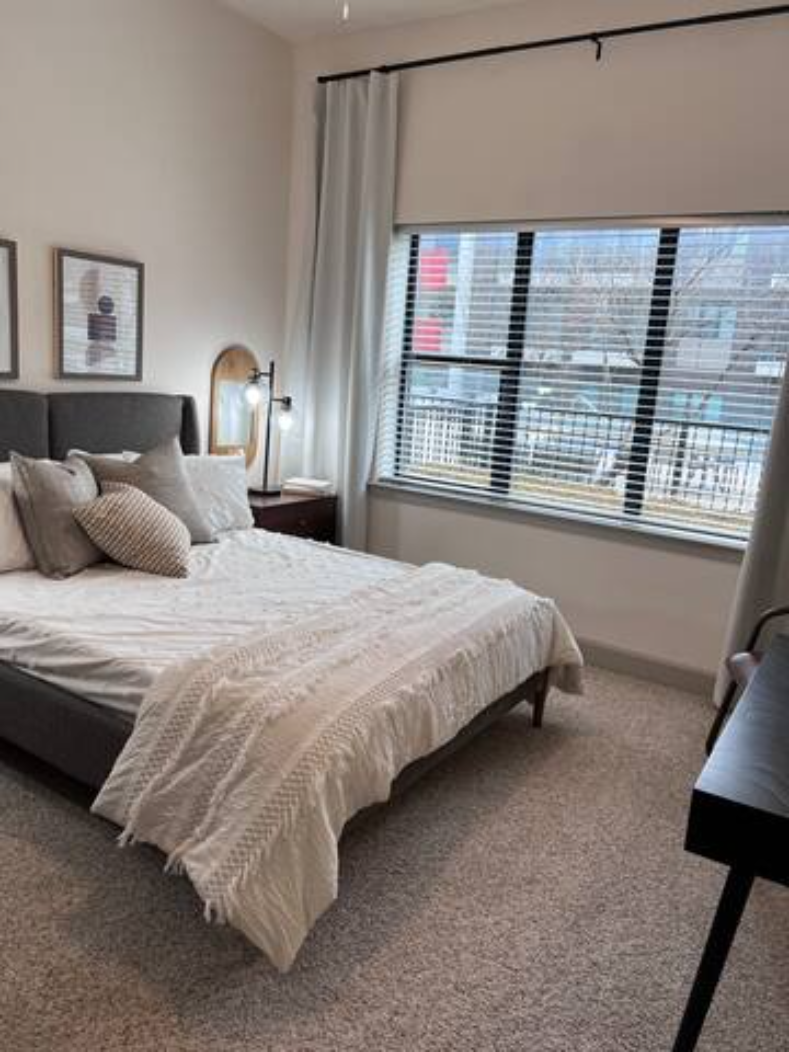 a bedroom with a bed and a large window