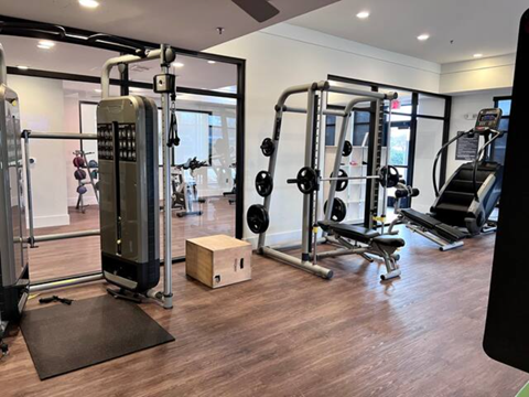 a gym with weights and other equipment on a wooden floor
