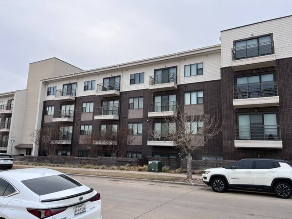an apartment building with cars parked in front of it