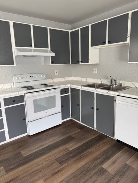 A kitchen with white appliances and grey cabinets.