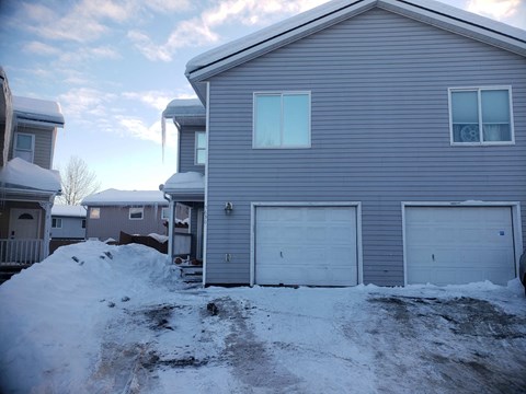 a house with two garage doors in the snow