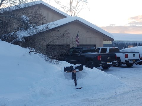 a parking meter in the snow in front of a building