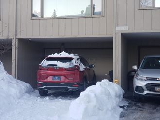 a red car parked in a garage in the snow
