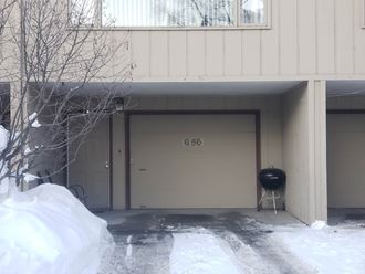 the front door of a building with a grill in the snow