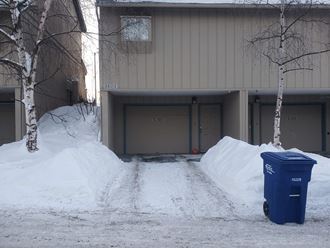 a driveway covered in snow in front of a building