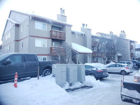 a apartment building with cars parked in a parking lot