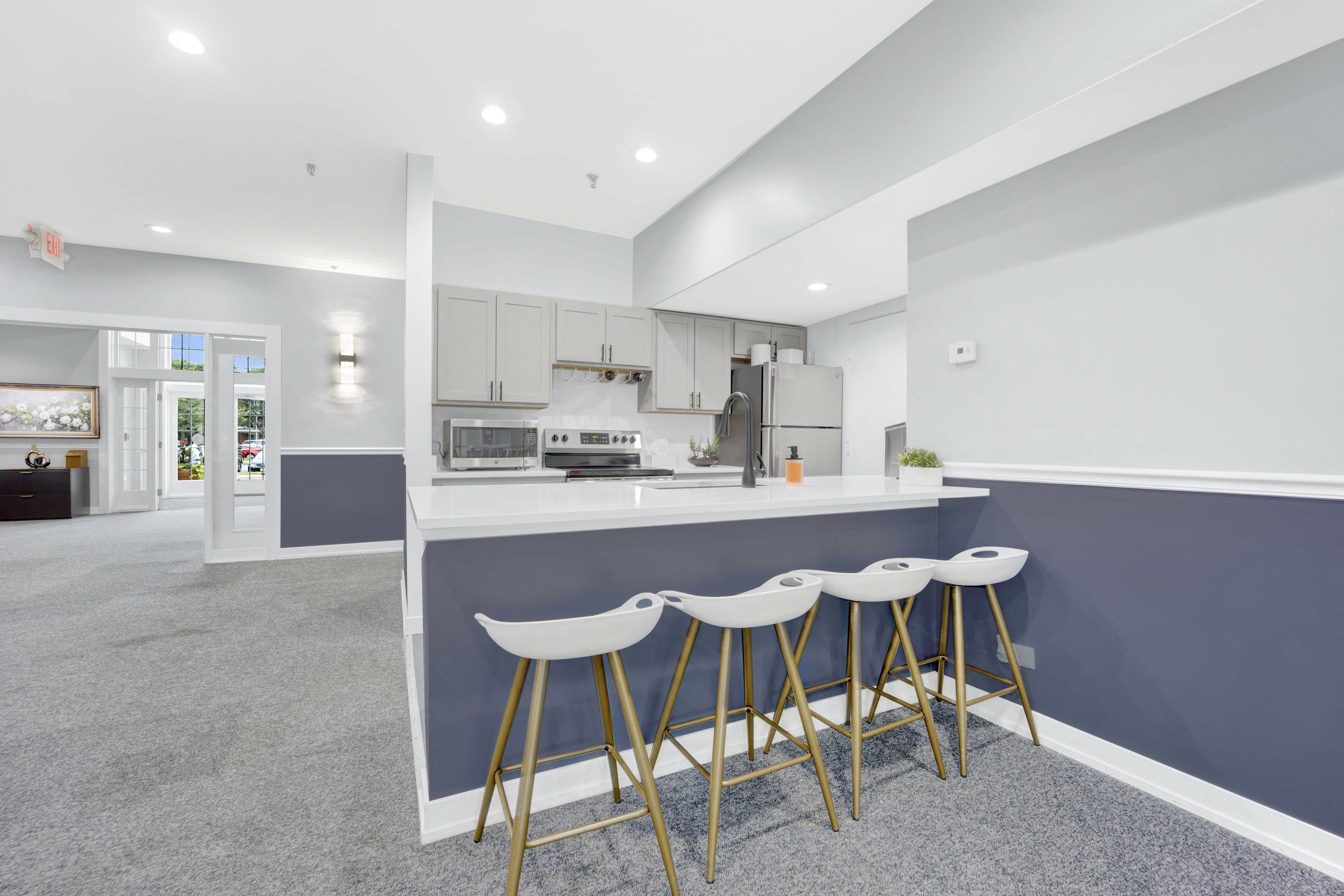 a kitchen with a blue counter and three stools