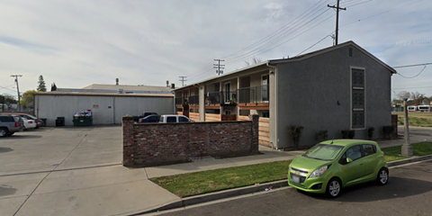 a green car parked in front of an apartment building