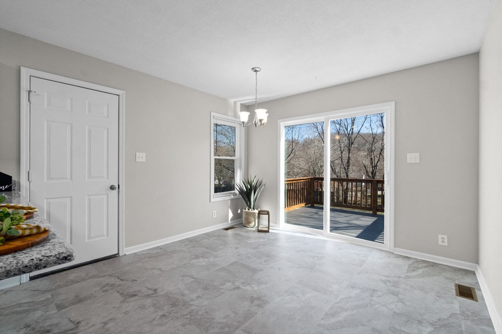 an empty living room with a sliding glass door to a patio