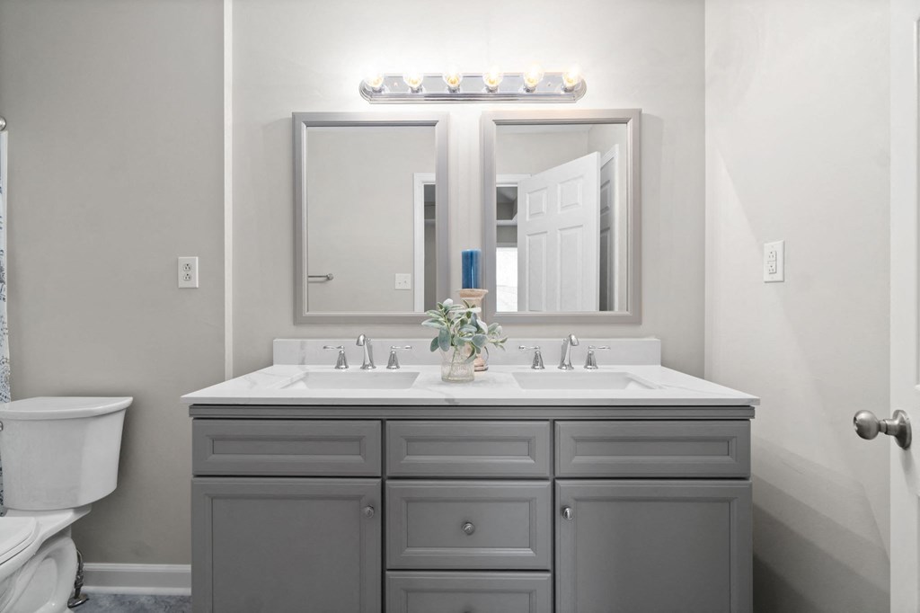 a white bathroom with two sinks and a mirror