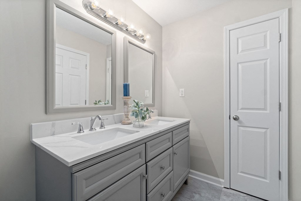 a bathroom with a sink and a mirror and a door