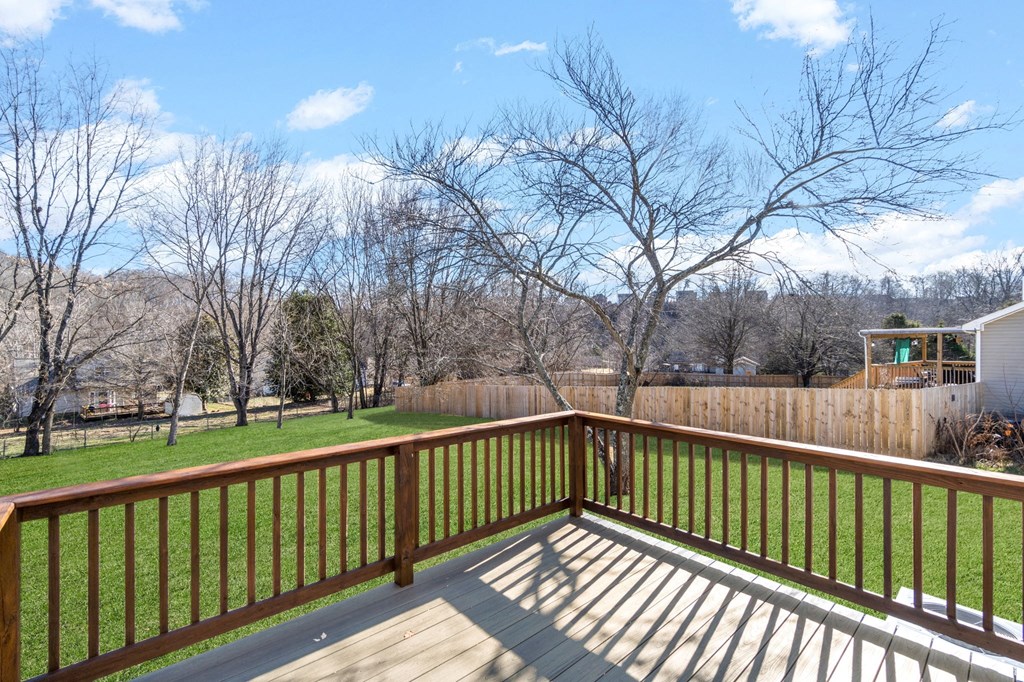 the deck has a view of the backyard and the trees