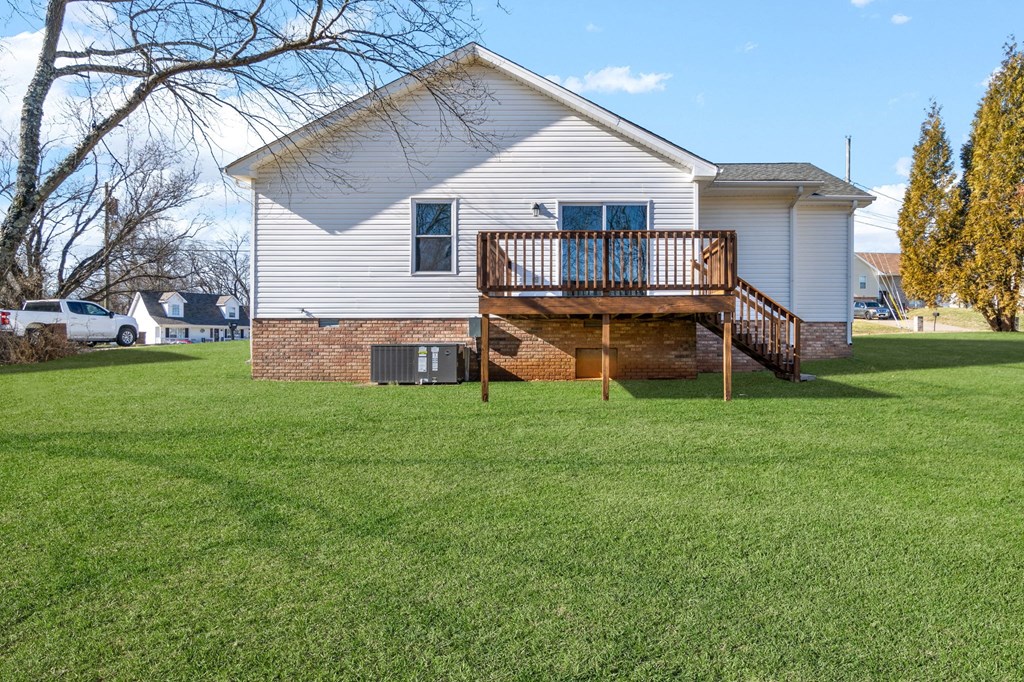 a white house with a deck on top of a yard
