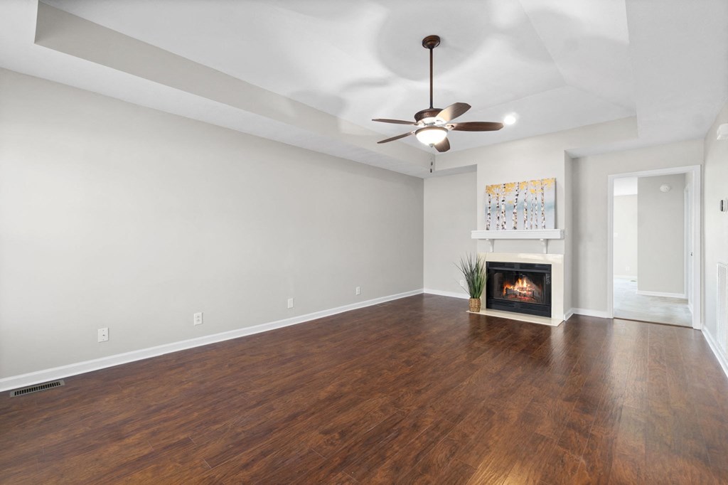 a living room with a fireplace and a ceiling fan