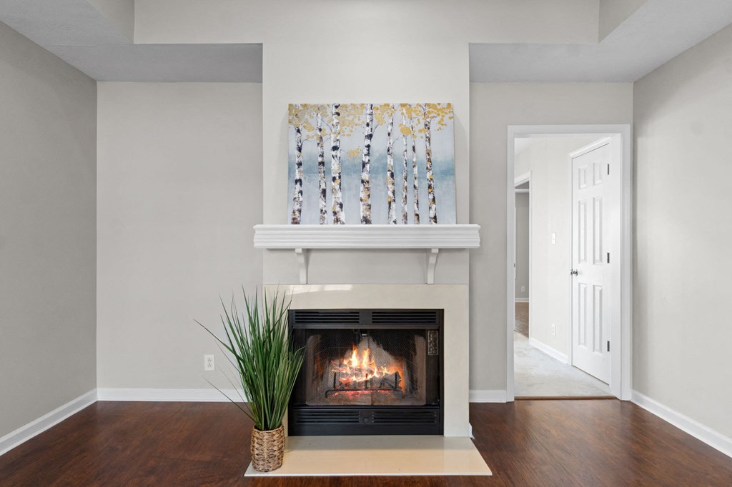 a living room with a fireplace and a painting on the wall