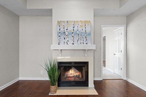 a living room with a fireplace and a painting on the wall