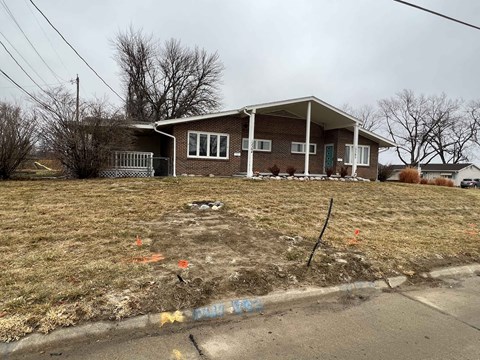 a house on a grassy yard with a dirt road