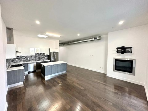 A spacious living room with a fireplace and hardwood floors.