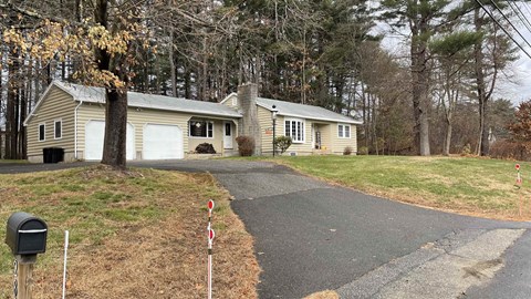 A house with a driveway and a mailbox in front.