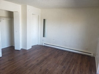 A room with wood floors and white walls.