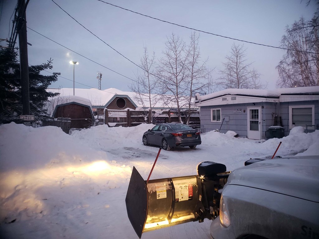 a car parked in the snow in front of a house
