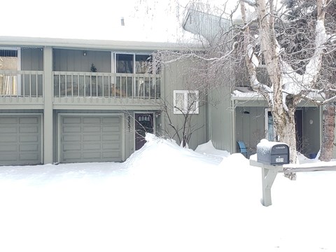 A grey building with a mailbox in front of it.