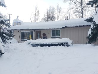 a house covered in snow with a table in front of it