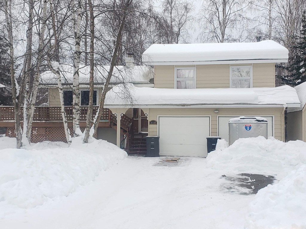 a house covered in snow with a white garage door