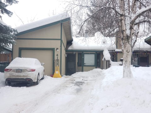 a house with a car parked outside in the snow