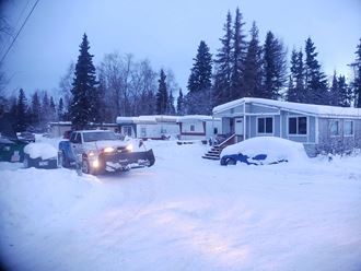 a truck parked in the snow in front of a house