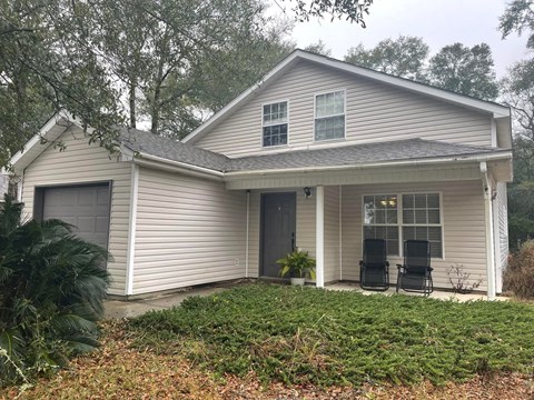 A house with a grey roof and a white garage door.