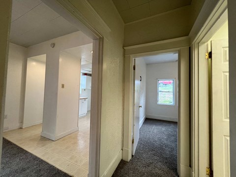 a view of a living room and a hallway with a door open
