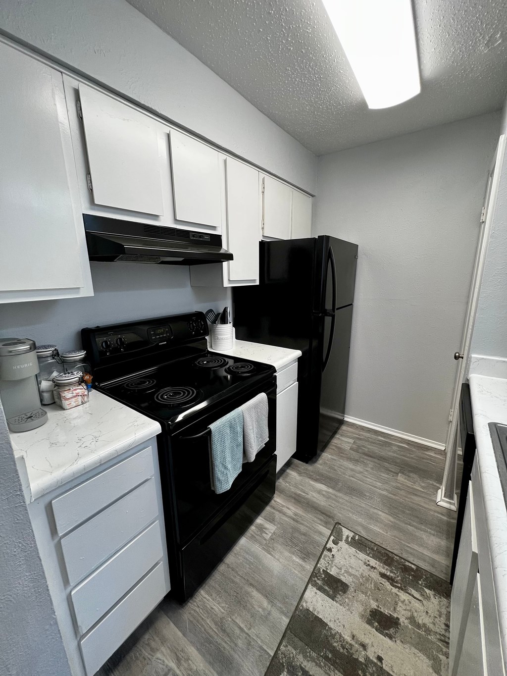a kitchen with black appliances and white cabinets