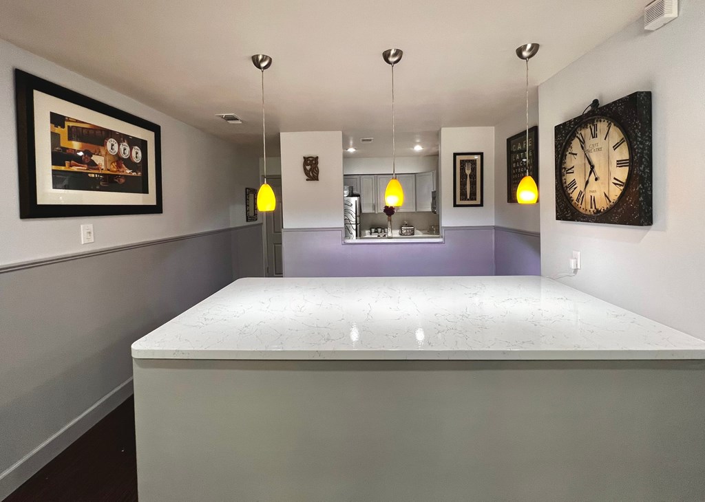 a bar in a room with a counter top and a clock on the wall