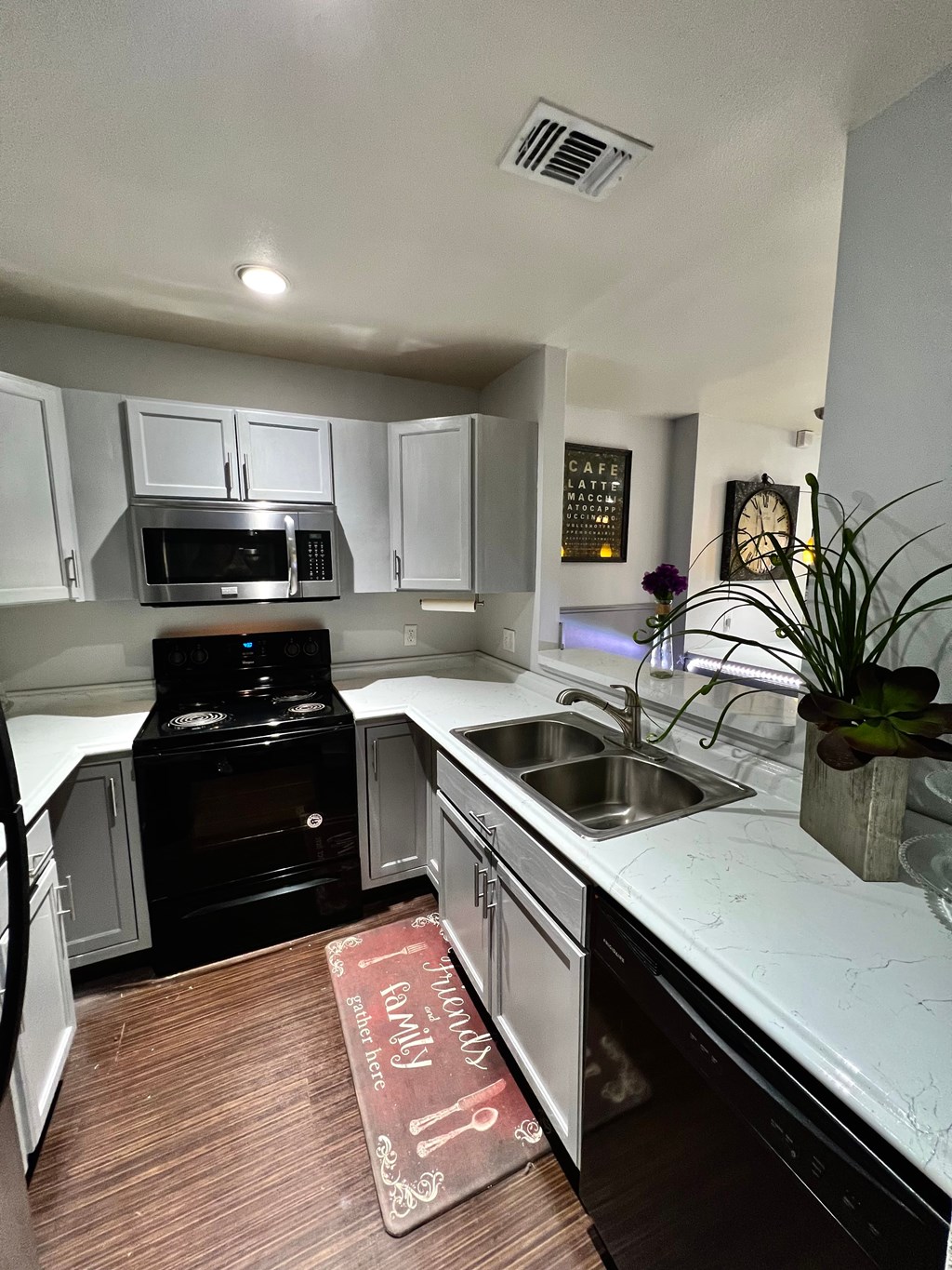 a kitchen with white cabinets and black appliances and a sink