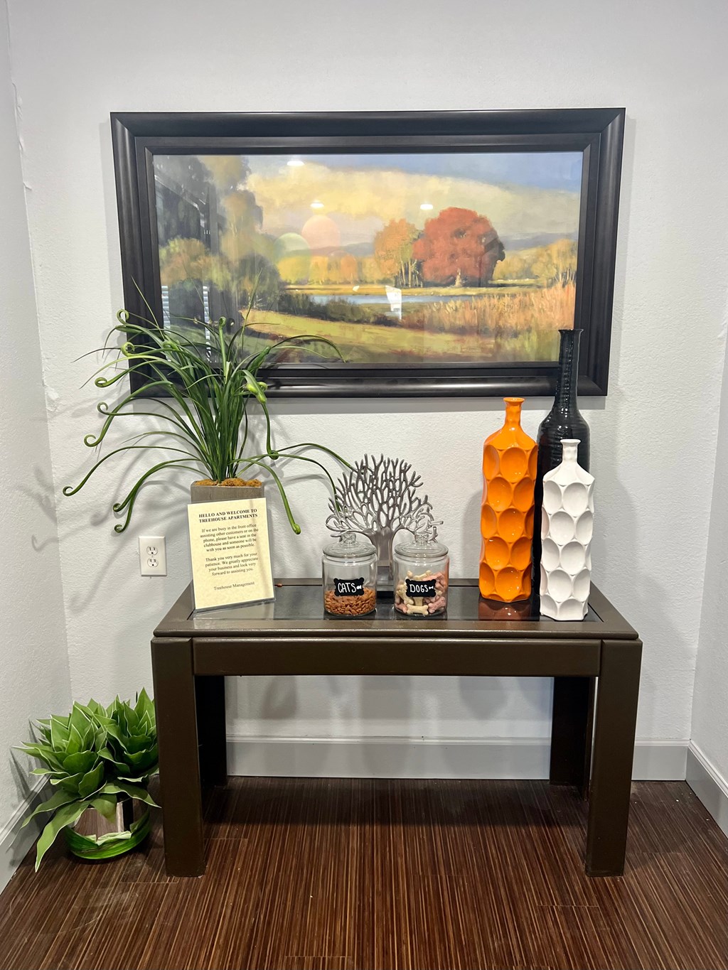 a table with bottles and a painting on the wall
